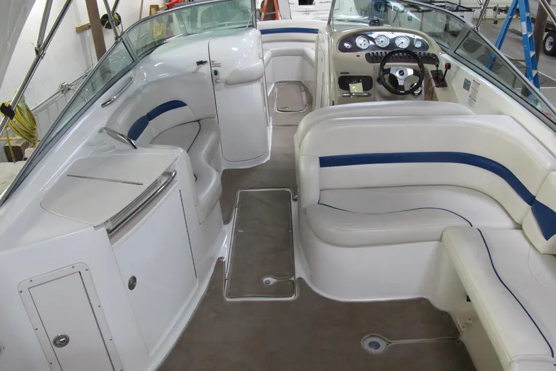 Slide: The Image of 2003 Chaparral 280 SSi boat interior with white and blue seating, steering console, and storage. - 3
