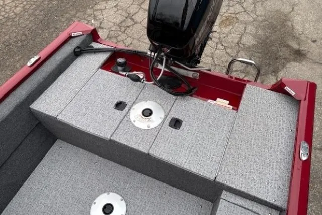 Slide: The Image of 2021 Tracker Super Guide V-16 SC boat interior with motor, gray carpet, and red trim. - 18