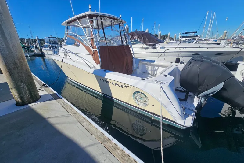 Slide: The Image of 2006 Pro-Line 32 Express boat docked at marina under clear blue sky. - 2