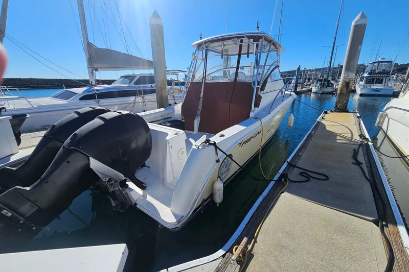 Slide: The Image of 2006 Pro-Line 32 Express boat docked at marina, featuring dual outboard motors. - 4