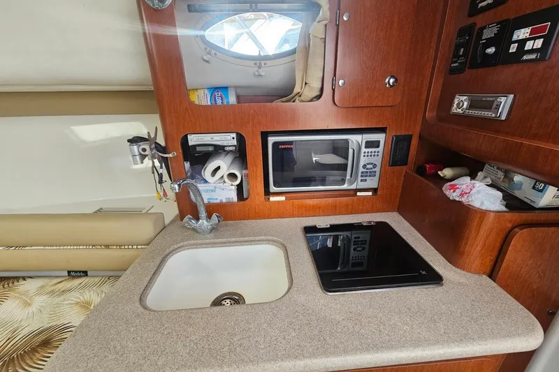 Slide: The Image of 2006 Pro-Line 32 Express boat interior with kitchenette, sink, and microwave. - 9