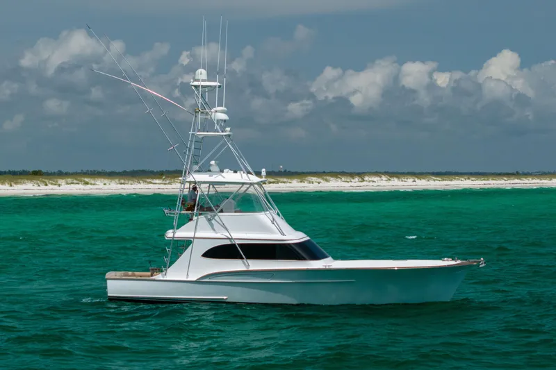 The Image of Custom Carolina Alex Willis Convertible 2000 yacht on turquoise waters near sandy shoreline. - 0