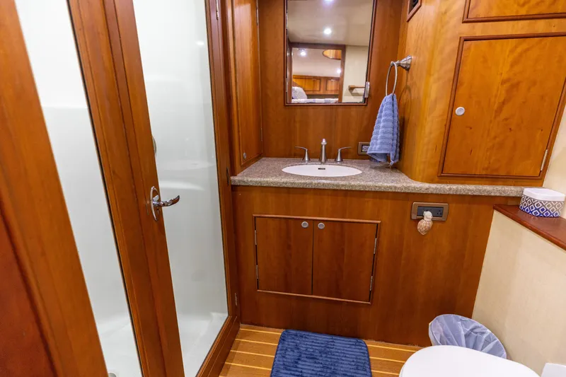 Slide: The Image of Luxurious bathroom in 2000 Custom Carolina Alex Willis Convertible yacht, featuring wood cabinetry and modern fixtures. - 12
