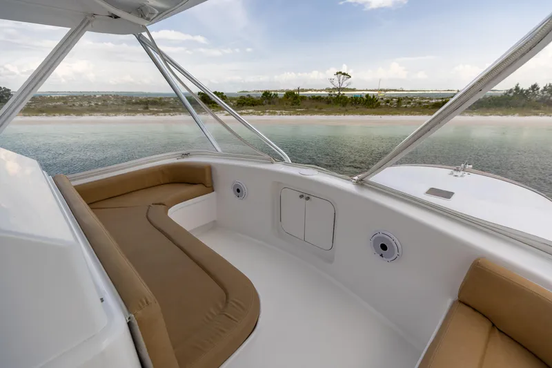 Slide: The Image of Custom Carolina Alex Willis Convertible 2000 boat interior with tan seating, overlooking serene waters. - 3