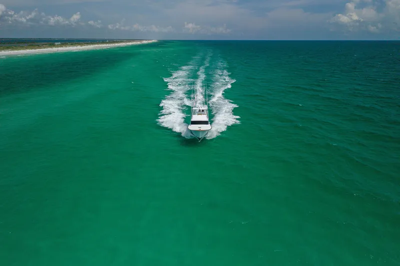 Slide: The Image of Custom Carolina Alex Willis Convertible boat cruising in turquoise ocean waters, 2000 model. - 33
