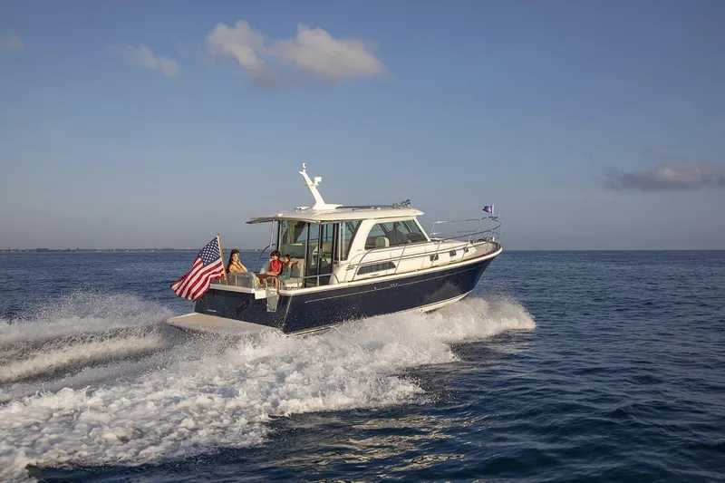 The Image of 2027 Sabre 38 Salon Express cruising on open water, American flag displayed. - 0