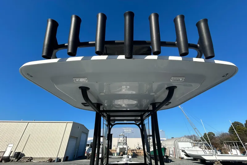 Slide: The Image of 2017 Baker Boatworks 26 Open with rod holders, viewed from below against a clear blue sky. - 11