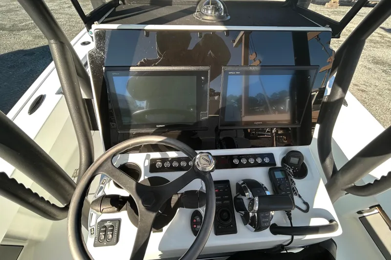 Slide: The Image of 2017 Baker Boatworks 26 Open dashboard with steering wheel, controls, and navigation screens. - 5