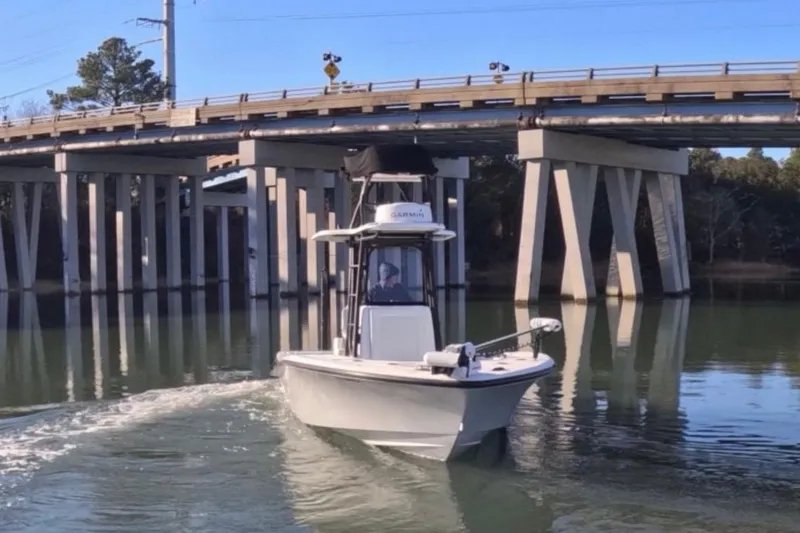 Slide: The Image of 2017 Baker Boatworks 26 Open navigating under a bridge on a calm waterway. - 2