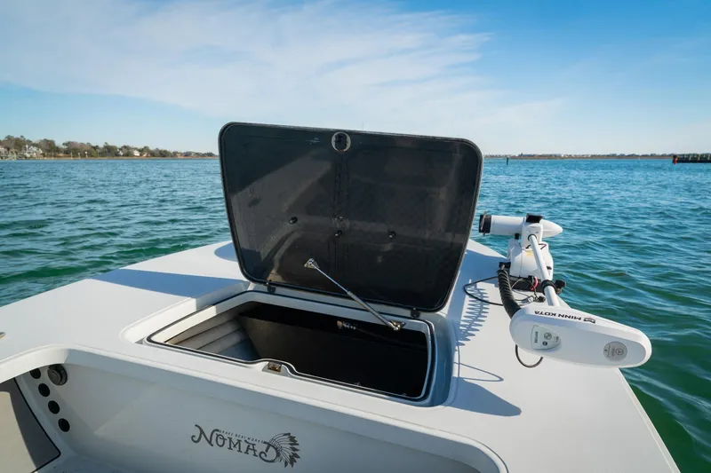 Slide: The Image of 2021 Drake Nomad boat with open storage compartment on calm water. - 11
