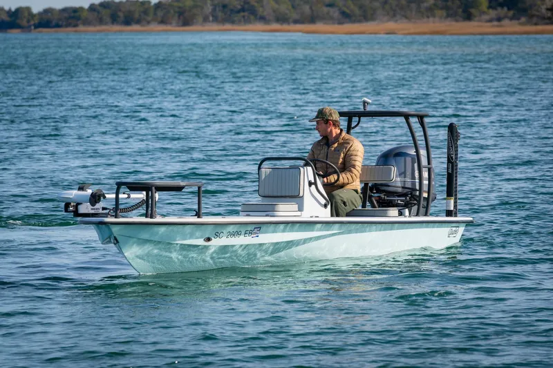 Slide: The Image of 2021 Drake Nomad boat on water with person steering, scenic background. - 3