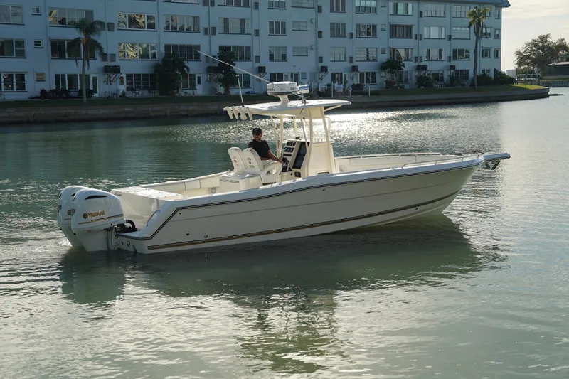 The Image of 2013 Stamas 317 Tarpon boat cruising on calm water near waterfront buildings. - 0