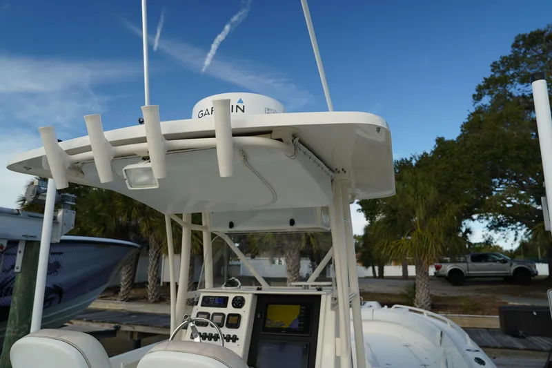 Slide: The Image of 2013 Stamas 317 Tarpon boat with Garmin equipment, docked under a clear blue sky. - 23