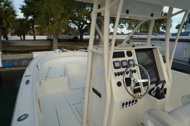 Slide: The Image of 2013 Stamas 317 Tarpon boat with steering console, docked near palm trees. - 24