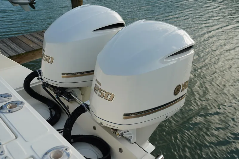 Slide: The Image of Twin Yamaha outboard engines on a 2013 Stamas 317 Tarpon boat by the water. - 8