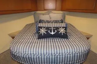 Slide: The Image of 2011 Henriques 42 Flybridge cabin with striped bedding and nautical-themed pillows. - 10