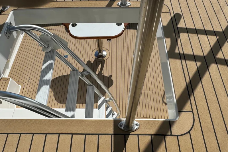 Slide: The Image of Henriques 42 Flybridge 2011 boat deck with ladder and table, featuring wood finish. - 16