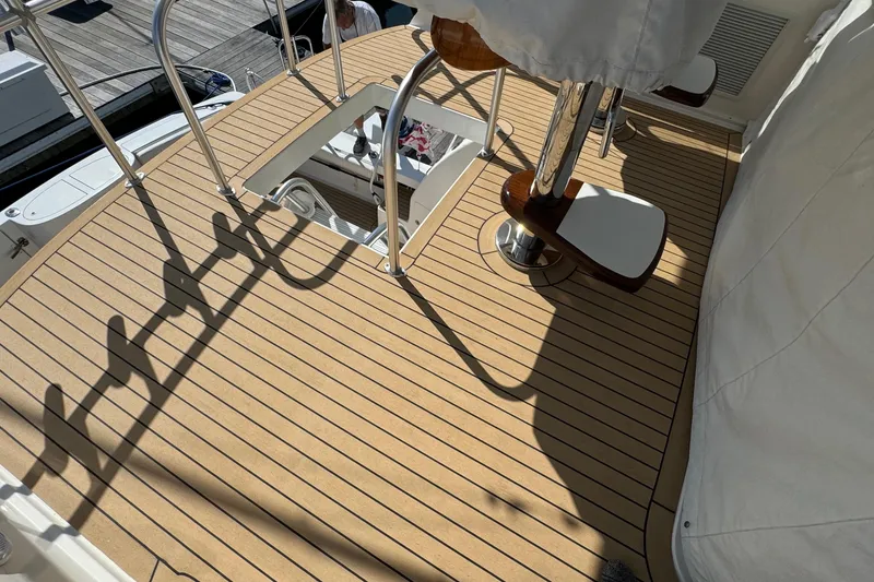Slide: The Image of Henriques 42 Flybridge 2011 boat deck with wooden finish and metal railings. - 18