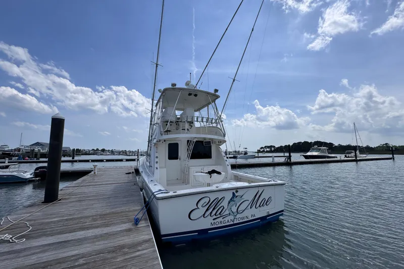 Slide: The Image of 2011 Henriques 42 Flybridge yacht docked at marina under blue sky. - 2