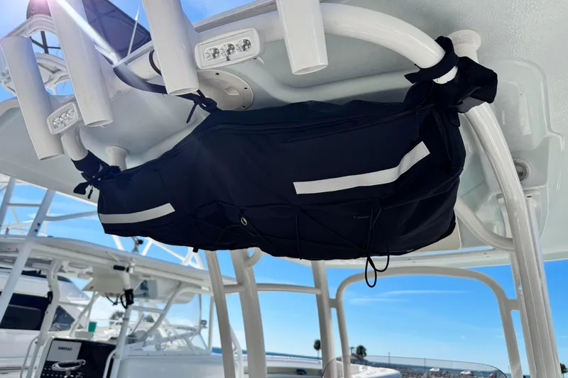 Slide: The Image of 2020 Robalo R222 Center Console boat with rod holders and storage bag under T-top. - 13