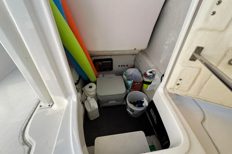 Slide: The Image of Storage compartment in 2020 Robalo R222 Center Console boat with various items. - 18