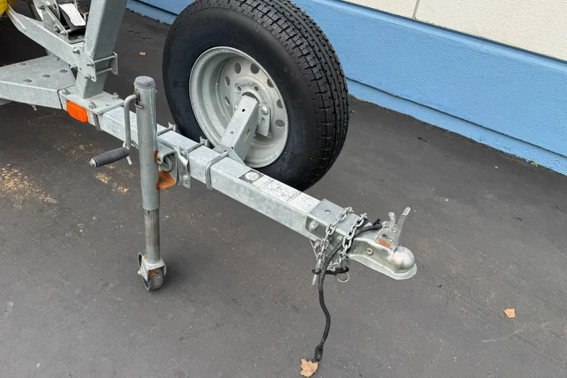 Slide: The Image of Trailer hitch and wheel of a 2000 Crestliner 1650 Fish Hawk boat on pavement. - 11