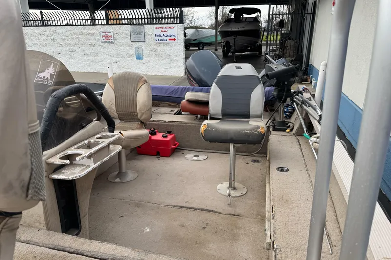 Slide: The Image of 2000 Crestliner 1650 Fish Hawk interior with worn seats and fishing equipment. - 13