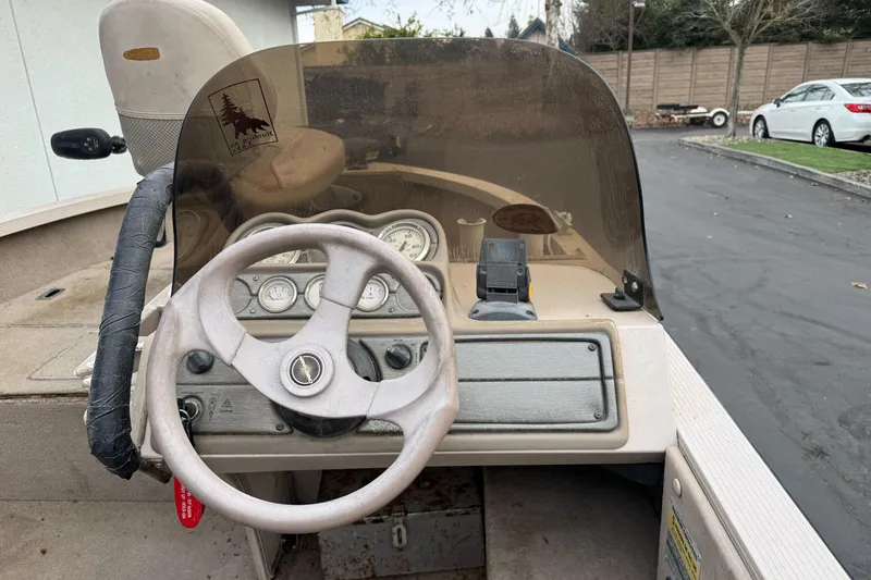 Slide: The Image of 2000 Crestliner 1650 Fish Hawk boat dashboard with steering wheel and gauges. - 8