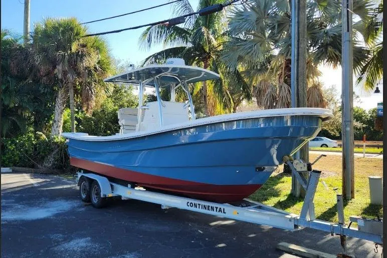 Slide: The Image of 2013 Panga Center Console boat on trailer, surrounded by palm trees. - 9
