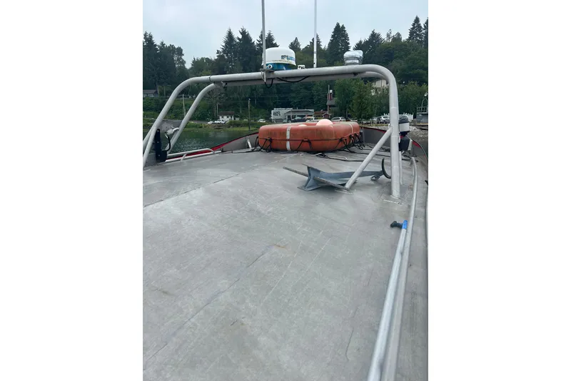 Slide: The Image of 1994 Svendsen Marine Works SMW 38 boat deck with lifebuoy and anchor, docked near trees. - 34