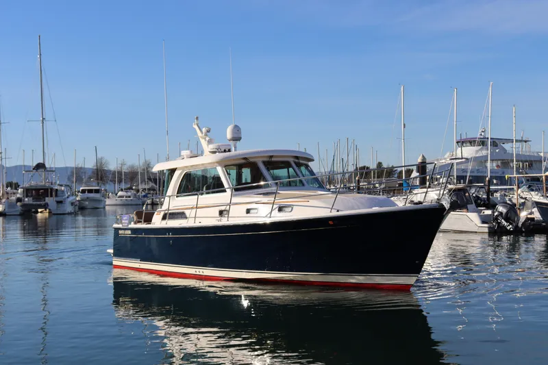 The Image of 2013 Sabre 38 Salon Express yacht docked in a marina under clear blue skies. - 0