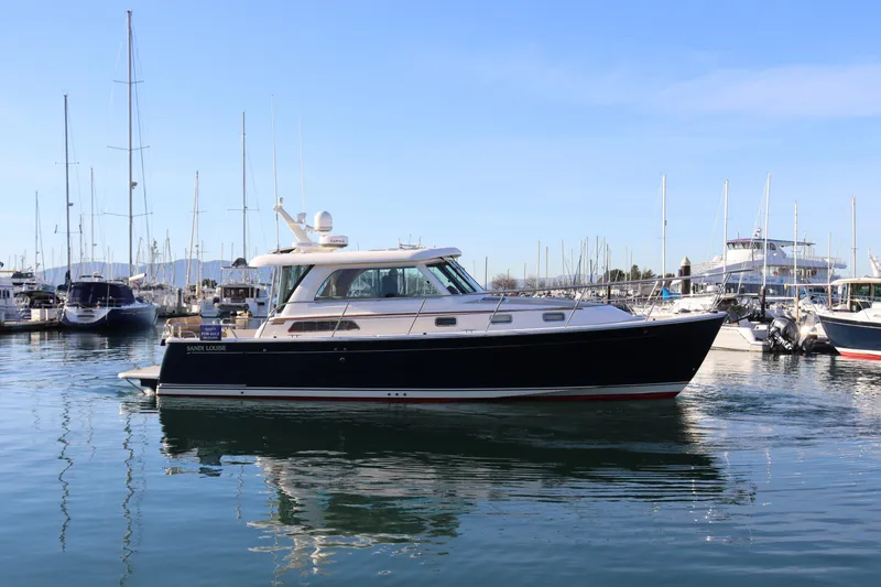 Slide: The Image of 2013 Sabre 38 Salon Express yacht docked in a marina under clear blue skies. - 1