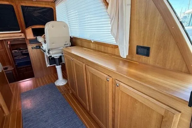 Slide: The Image of 2013 Sabre 38 Salon Express interior with wooden cabinetry and captain's chair. - 18