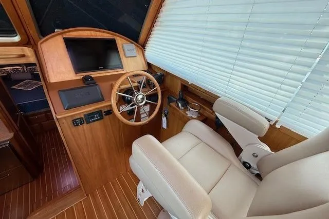 Slide: The Image of 2013 Sabre 38 Salon Express helm with wooden steering wheel and leather captain's chair. - 19