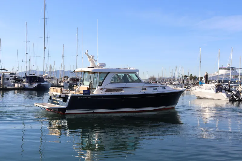 Slide: The Image of 2013 Sabre 38 Salon Express yacht docked in a marina under clear blue skies. - 2