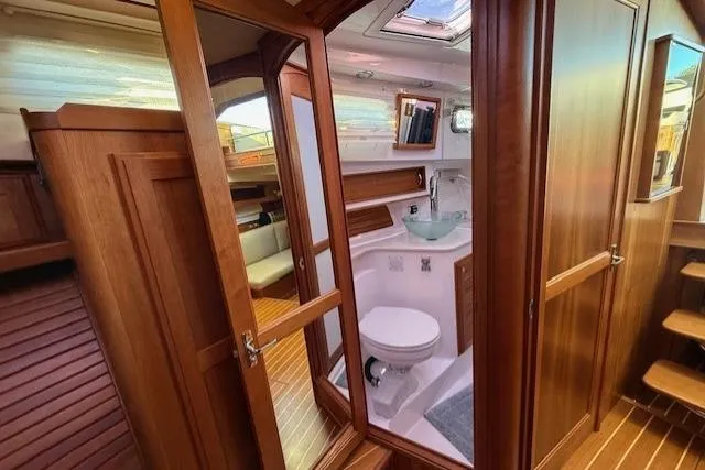 Slide: The Image of 2013 Sabre 38 Salon Express interior with wooden cabinetry and compact bathroom. - 34