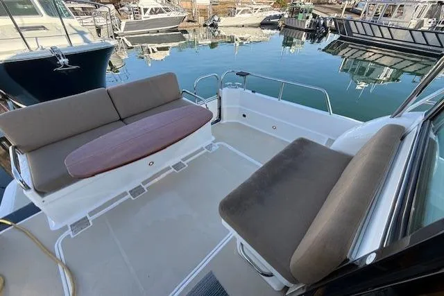 Slide: The Image of 2013 Sabre 38 Salon Express yacht with spacious outdoor seating area at a marina. - 8