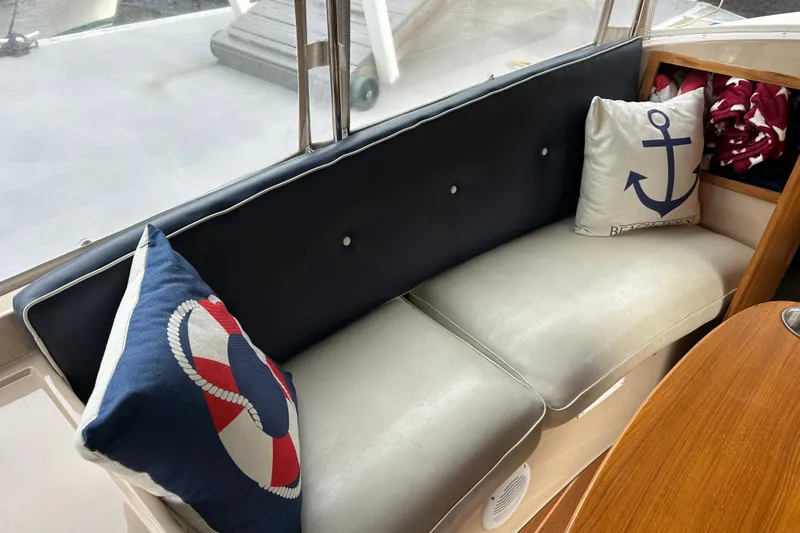 Slide: The Image of Cozy seating area on a 2011 Duffy 22 boat with nautical-themed pillows. - 10