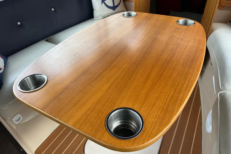 Slide: The Image of Wooden table with cup holders inside a 2011 Duffy 22 boat interior. - 12