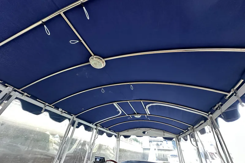 Slide: The Image of Interior view of 2011 Duffy 22 boat with blue canopy and metal framework. - 13