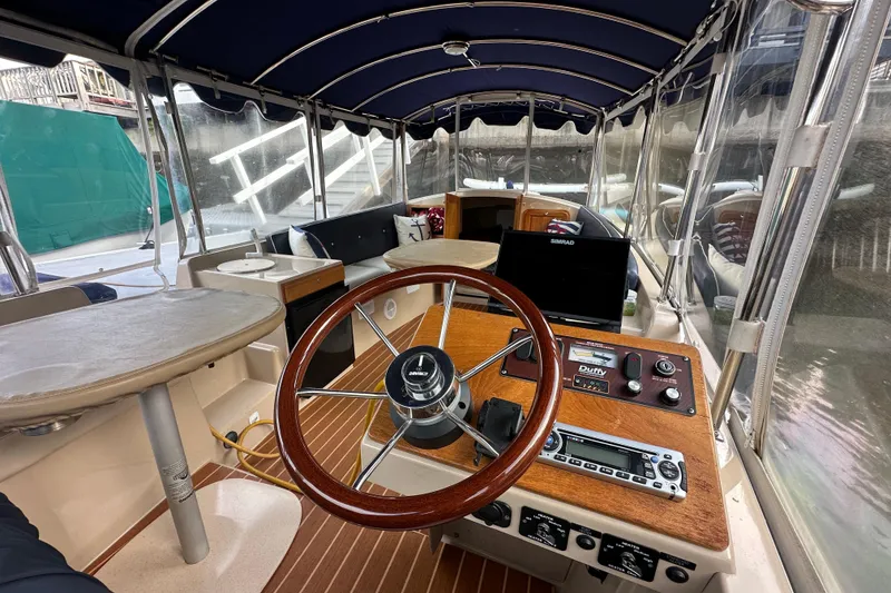 Slide: The Image of Interior of a 2011 Duffy 22 boat with steering wheel and navigation equipment. - 3