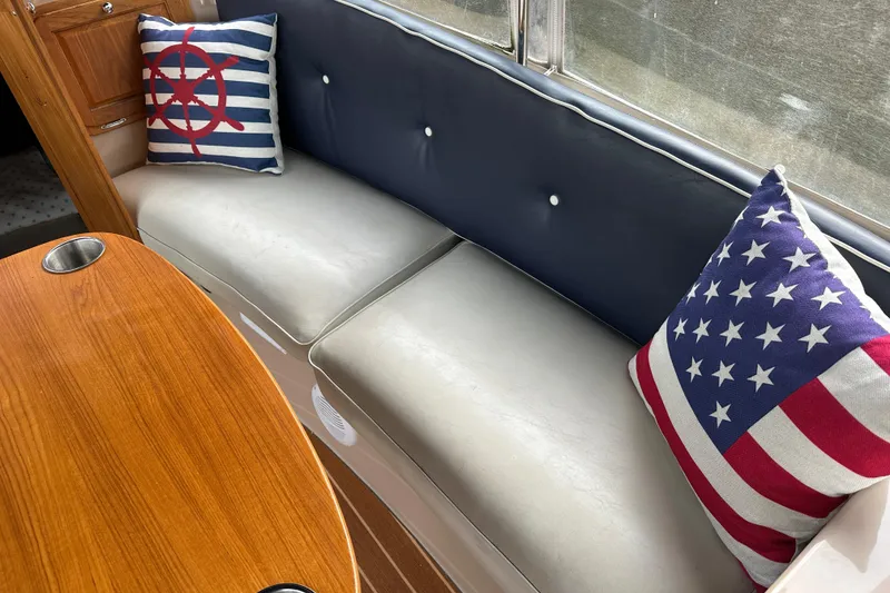 Slide: The Image of Interior of 2011 Duffy 22 boat with nautical-themed cushions and wooden table. - 9