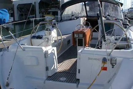 Slide: The Image of 1999 Jeanneau Sun Odyssey 45.2 sailboat with dual steering wheels in a marina. - 14