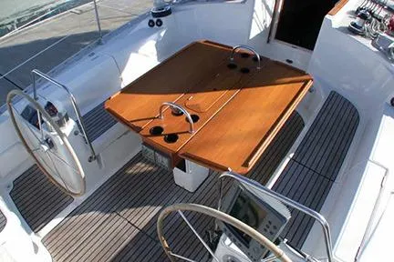 Slide: The Image of Cockpit of 1999 Jeanneau Sun Odyssey 45.2 sailboat with dual steering wheels and wooden table. - 15