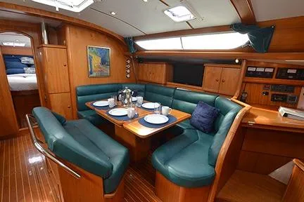 Slide: The Image of 1999 Jeanneau Sun Odyssey 45.2 yacht interior with dining area and wooden finish. - 20
