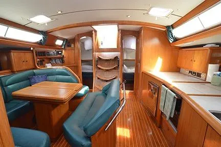 Slide: The Image of Interior of 1999 Jeanneau Sun Odyssey 45.2 yacht with wood finish and seating area. - 23