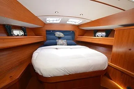 Slide: The Image of 1999 Jeanneau Sun Odyssey 45.2 cabin interior with cozy bed and wooden finish. - 24
