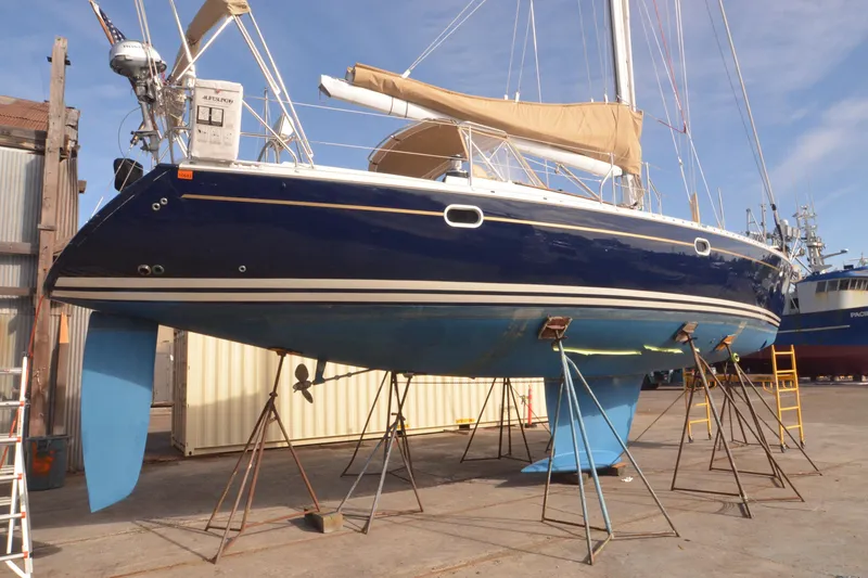 Slide: The Image of 1999 Jeanneau Sun Odyssey 45.2 sailboat on stands, blue hull, dockside view. - 7