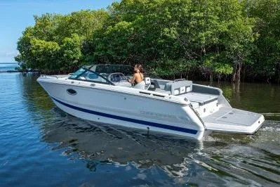 The Image of 2026 Chaparral SSX 4 boat cruising on calm water near lush greenery. - 0