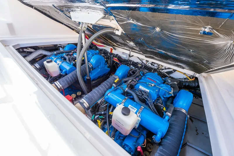 Slide: The Image of Engine compartment of a 2000 Tiara 31 Open boat, featuring dual blue engines. - 10